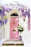This image feels like a quiet Barnsbury afternoon distilled into a single welcoming doorway, the kind of entrance you might discover turning off Liverpool Road onto a quieter residential street. A soft pink front door anchors the composition, its colour a gentle, comforting blush that suggests warmth and hospitality. The paint appears freshly applied yet understated, giving the door a smooth, almost velvety look in the dappled light. Either side, whitewashed walls and a softly painted shutter offer a calm, neutral frame, allowing the floral details to sing without distraction. Above, wisteria blossoms pour down in generous cascades, their lavender tones weaving a dreamy canopy around the entrance. Each cluster is made up of countless tiny petals, creating long, graceful strands that sway visually, as though responding to the slightest breeze. The palette of purples and lilacs is soothing, and it's easy to imagine the delicate fragrance mixing with the urban air. At the foot of the door, resting on the stone step, a simple grey metal bucket holds a luxurious bouquet of white and cream roses. The roses are at their peak, densely petalled and softly rounded, with a plush texture that suggests freshness and careful handling. Threads of soft green foliage peek between the blooms, giving gentle contrast and movement. A blush-pink ribbon encircles the bucket, tied into a neat bow whose satin ends drape gracefully across the step, echoing the colour of the door. The atmosphere is poised between serenity and anticipation, as if a Barnsbury florist has just delivered this arrangement to mark move-in day. It's a tender visual story of housewarming flowers: understated, elegant, and full of quiet hope for the life that will unfold behind that pastel door.