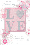 In this image, a softly romantic anniversary card is displayed, its design built around gentle pastel pinks and cool silvery greys that mirror the calm charm of Barnsbury's tree-lined terraces. At the centre, the word LOVE is spelled out in raised, glitter-touched letters that glimmer delicately, giving the card a textured focal point that feels both modern and sentimental. The letter O is transformed into a shimmering heart shape, filled with silver texture that stands out like a tiny jewel against the blush background. Surrounding this central word, clusters of delicate blossoms unfold in tones of blush, mauve, and creamy white, their edges softened to resemble watercolor petals. Fine, meandering lines create stems and subtle swirls, suggesting the gentle motion of vines growing along a garden wall near Islington's quiet side streets. Tiny flourishes-petals, loose curls, and the faint silhouettes of butterflies-dance around the flowers, lending a whimsical note without disturbing the card's overall elegance. The sentiments On Our Anniversary and I love you today and always are written in an understated, flowing script that feels sincere, like a private promise spoken between partners. The text is positioned so it balances the floral illustration, leaving open space that allows the design to breathe. As a whole, the card resembles a carefully composed floral arrangement on paper, the kind a local Barnsbury florist might pair with a fresh bouquet for same-day delivery-a gentle, heartfelt way to mark the journey of love shared over the years.